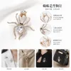 Three vintage crystal spider brooches, silver, gold and black alloy pins, Muslim-style white display stand undefined